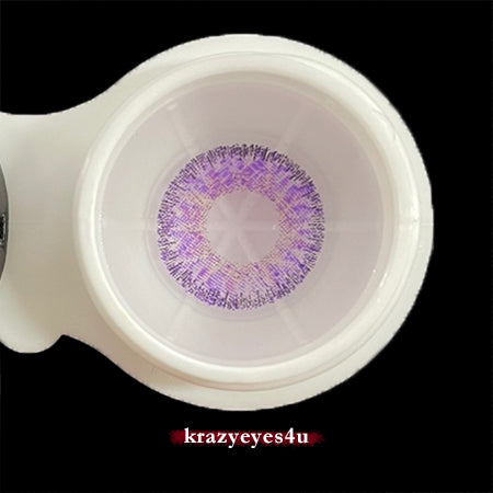 A violet colored contact lens is in lens case.