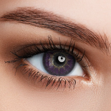 A woman is wearing violet contact lens with vibrant color.